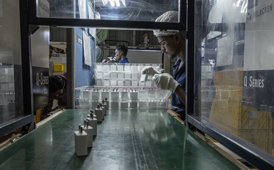 Linha de produção de carregadores de celular na Sancraft, em Sriperumbudur, Índia: peças de plástico para fornecedores da Apple