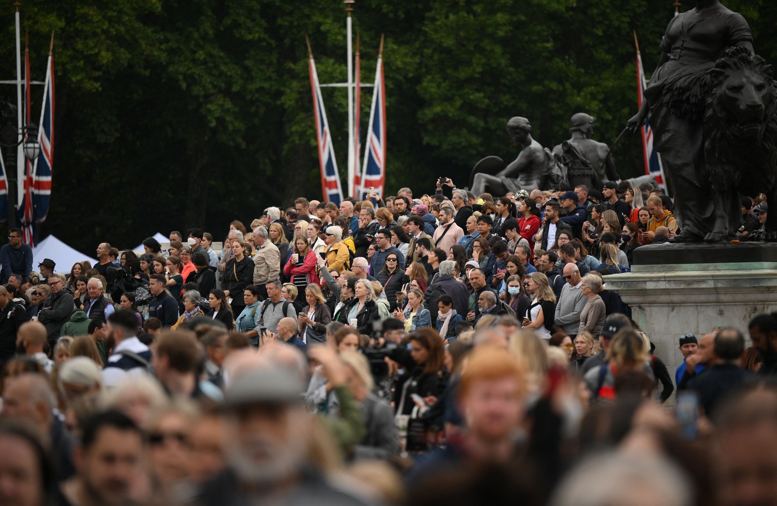 Pessoas se reúnem no Queen Victoria Memorial, em frente ao Palácio de Buckingham, em Londres — Foto: Daniel LEAL / AFP