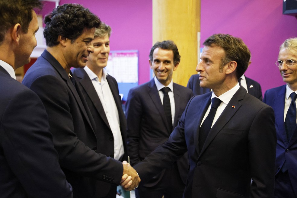 Macron cumprimenta o ex-jogador de futebol brasileiro Rai Souza durante uma reunião com membros da fundação Gol de Letra — Foto: Ludovic Marin / AFP