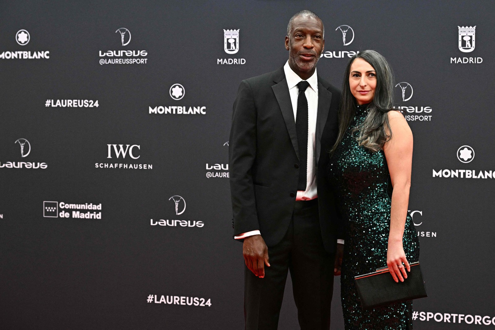 Velocista norte-americano, quatro medalhas de ouro olímpicas e vencedor de oito medalhas de ouro em campeonatos mundiais, Michael Johnson e sua parceira posam no tapete vermelho antes da 25ª gala do Laureus World Sports Awards em Madri — Foto: JAVIER SORIANO / AFP