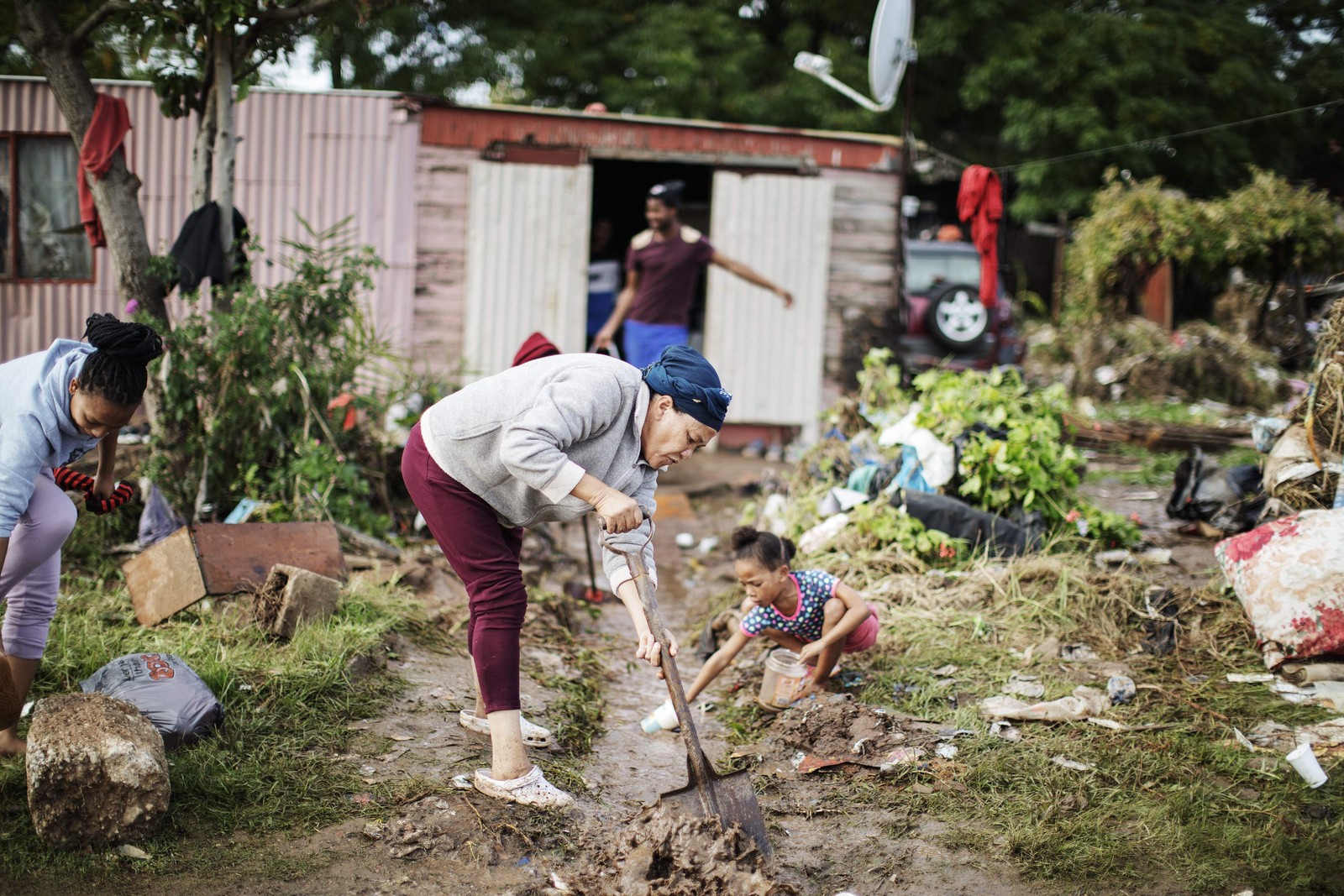 Moradores limpam as águas das enchentes de suas casas. As enchentes causadas por chuvas torrenciais e ventos fortes na costa leste da África do Sul mataram pelo menos 22 pessoas, disseram as autoridades locais na terça-feira. As inundações atingiram vários locais em duas províncias do leste, dois raros tornados foram detectados, as temperaturas caíram e a neve caiu em algumas regiões centrais. — Foto: GIANLUIGI GUERCIA/AFP