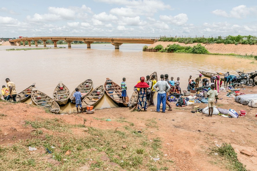 Passageiros esperam perto de canoas motorizadas prontas para atravessar o rio Níger, que divide Benin e Nigéria, em setembro