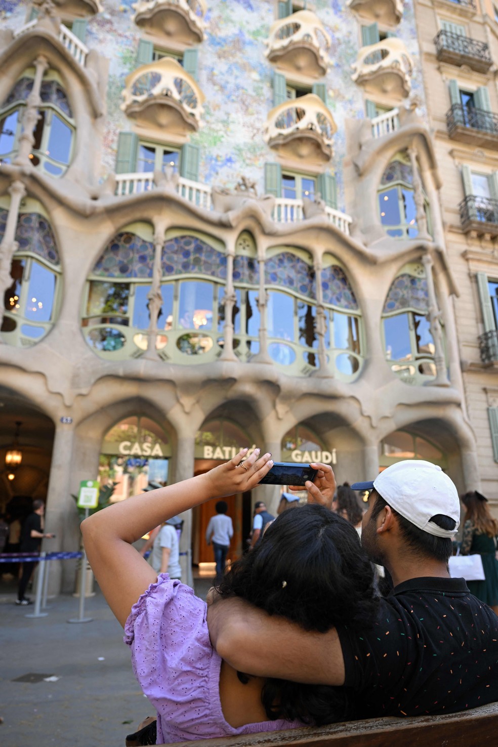 Turistas fotografam a icônica fachada da Casa Batlló, em Barcelona, na Espanha — Foto: Lluis Gene / AFP