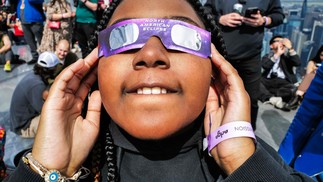 Uma jovem olha para o céu no deck de observação 'Edge at Hudson Yards' durante o eclipse solar na cidade de Nova York. — Foto: CHARLY TRIBALLEAU / AFP