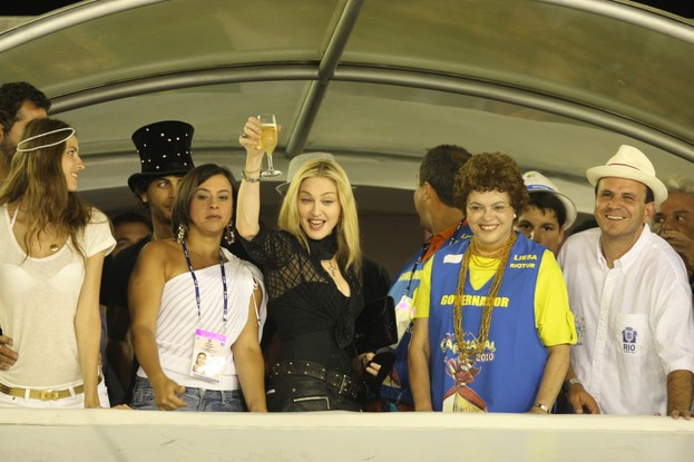 Madonna no carnaval de 2010, na Sapucaí, acompanhado de Jesus Luz, a então primeira-dama do Estado do Rio, Adriana Ancelmo, a então ministra da Casa Civil de Lula, Dilma Rousseff, e o prefeito Eduardo Paes