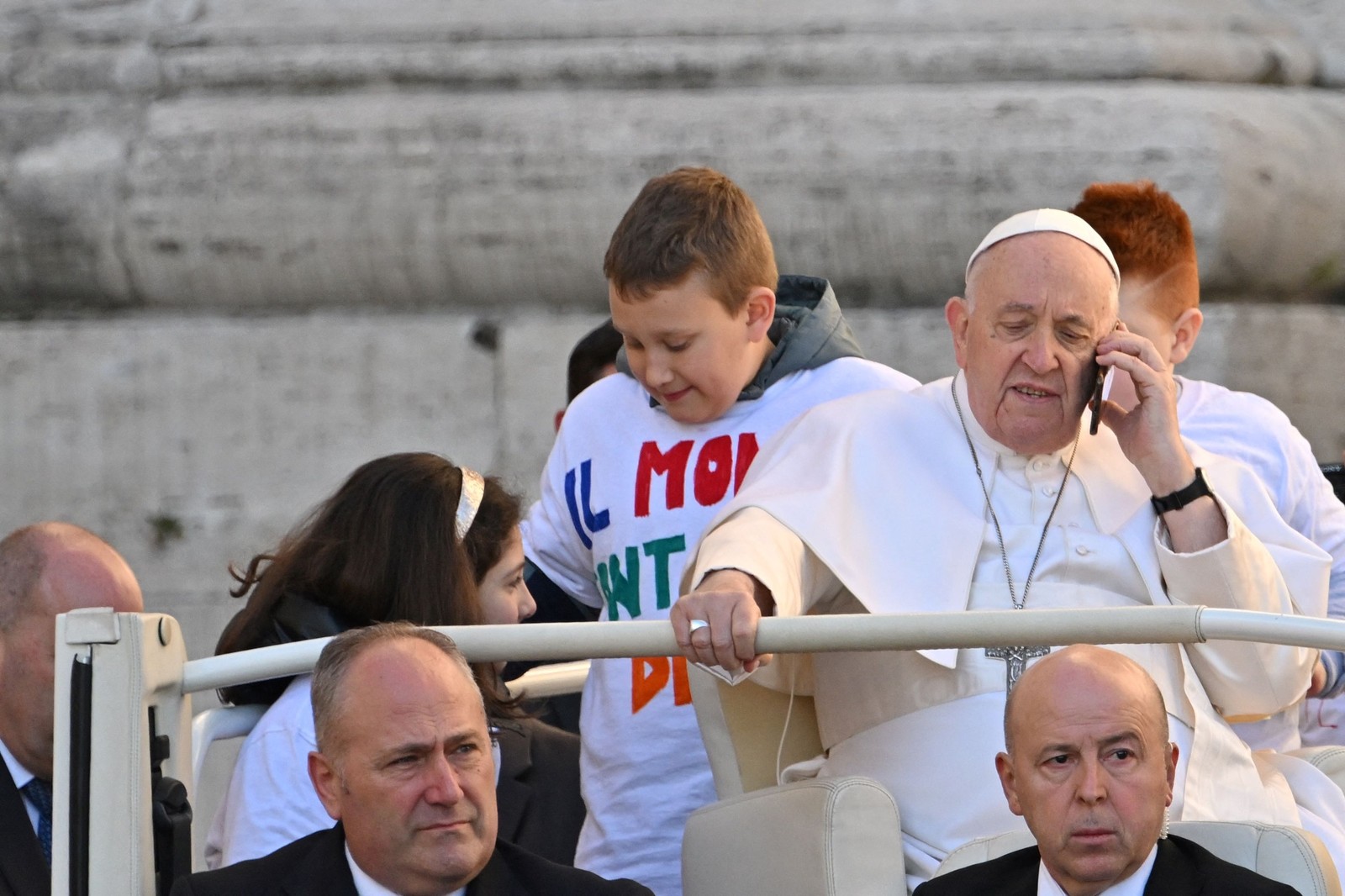 Papa Francisco dá um telefonema ao chegar para liderar sua audiência geral semanal ao ar livre na praça de São Pedro, no Vaticano — Foto: ALBERTO PIZZOLI/AFP