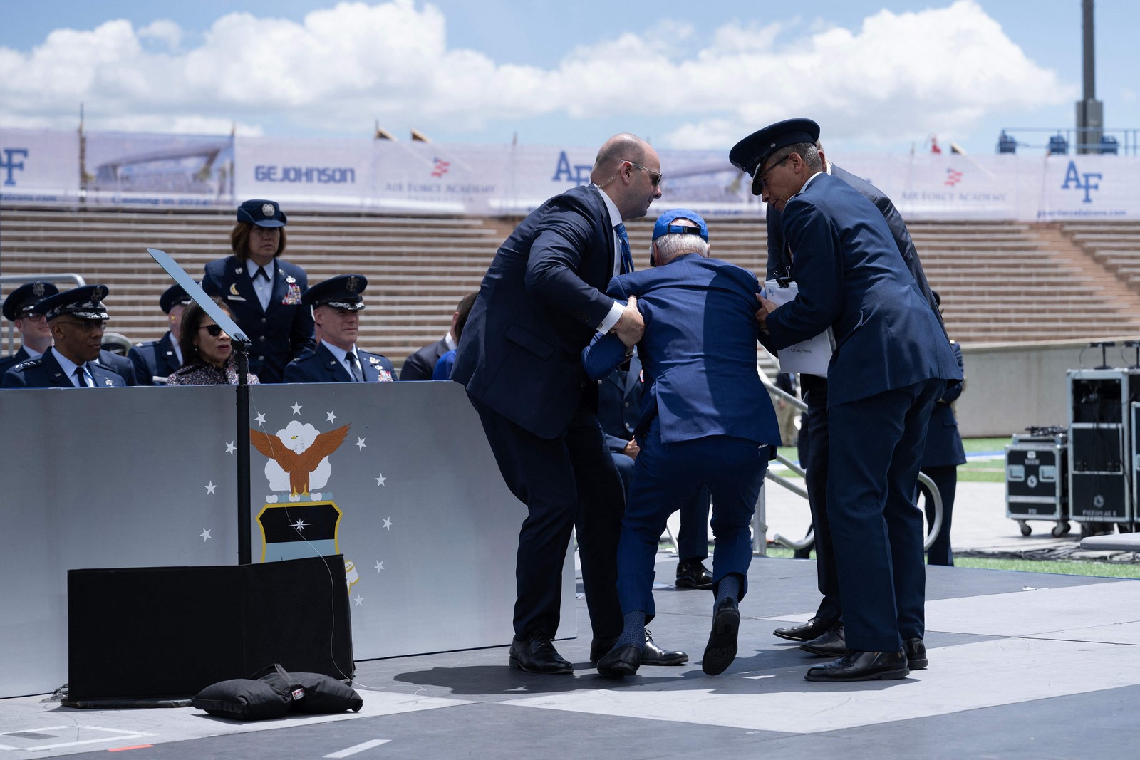 Logo após a queda, ele é amparado por um outro militar que estava perto e logo começa a se levantar. — Foto: Brendan Smialowski / AFP