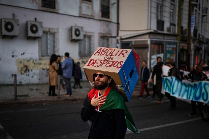 Manifestante pede o fim dos despejos em Portugal durante protesto de rua