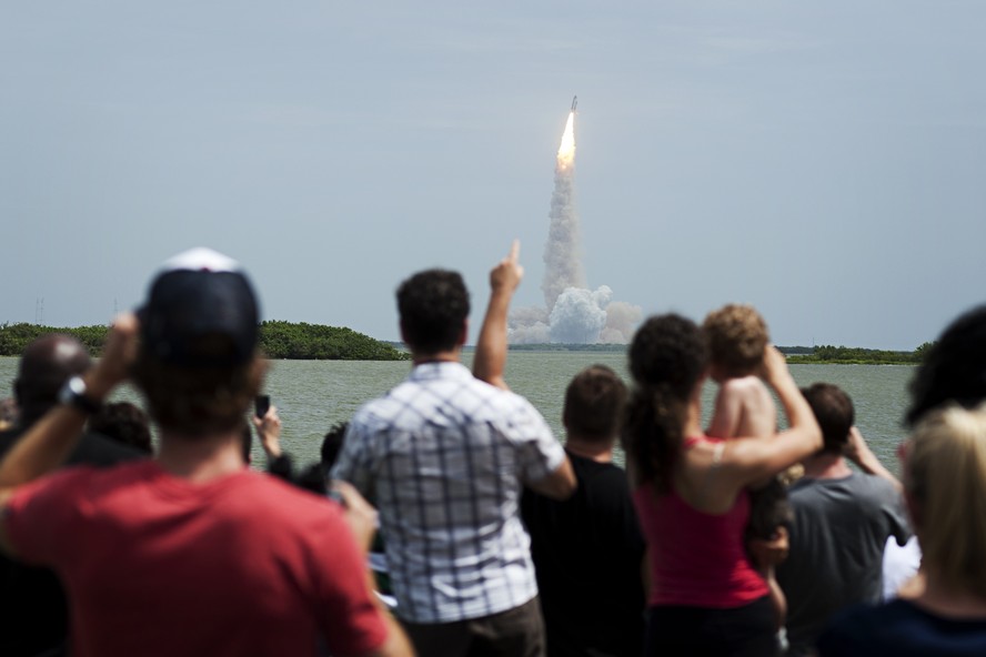 Pessoas assistem ao lançamento do ônibus espacial Atlantis no seu último voo a partir do Centro Espacial Kennedy em Cabo Canaveral, na Flórida, em 8 de julho de 2011