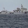 Um navio da Guarda Costeira da China (D) é visto passando pelo navio da Guarda Costeira das Filipinas - JAM STA ROSA / AFP