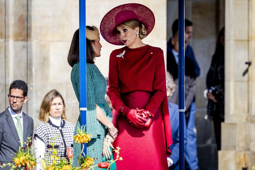 Rainha Maxima (de vermelho) conversa com a rainha Letizia, da Espanha, em cerimônia no Dam Square, Amsterdã, em 17 de abril