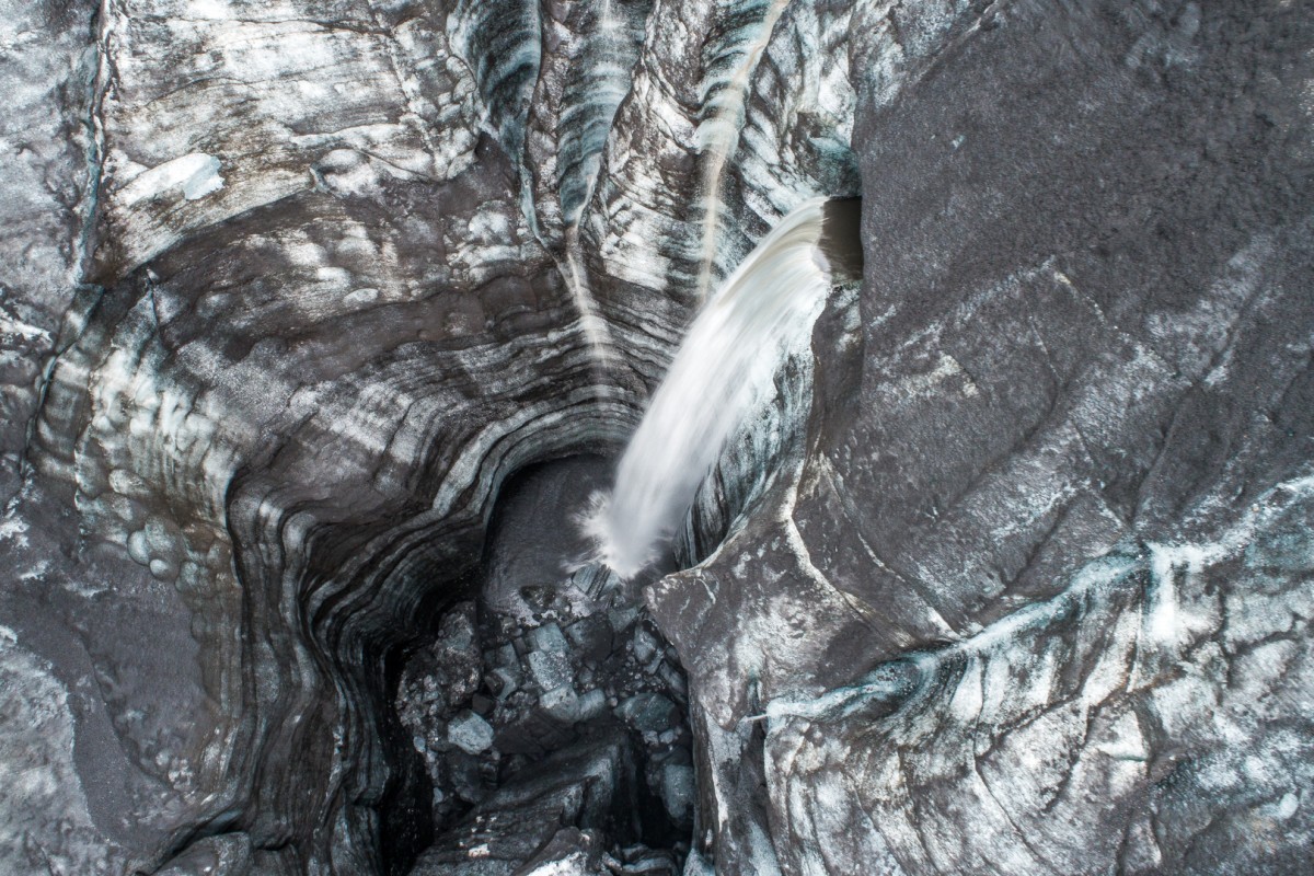 Rio sub-glacial vindo de dentro de uma geleira e caindo num grande buracoFlorian Ledoux