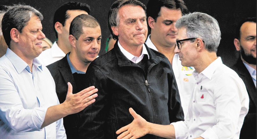 Tarcísio de Freitas cumprimenta Romeu Zema, com Bolsonaro ao fundo, em evento em São Paulo: governadores disputam espólio do ex-presidente