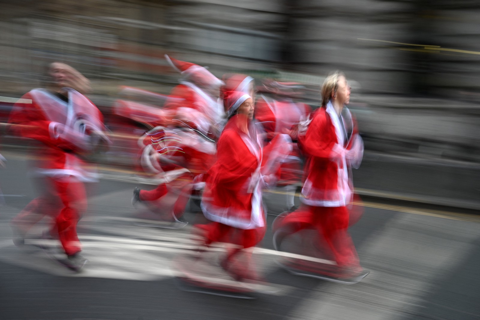Corredores vestidos de papai noel participam da Santa Dash, evento anual de cinco quilômetros na cidade de Liverpool, Inglaterra — Foto: OLI SCARFF/AFP