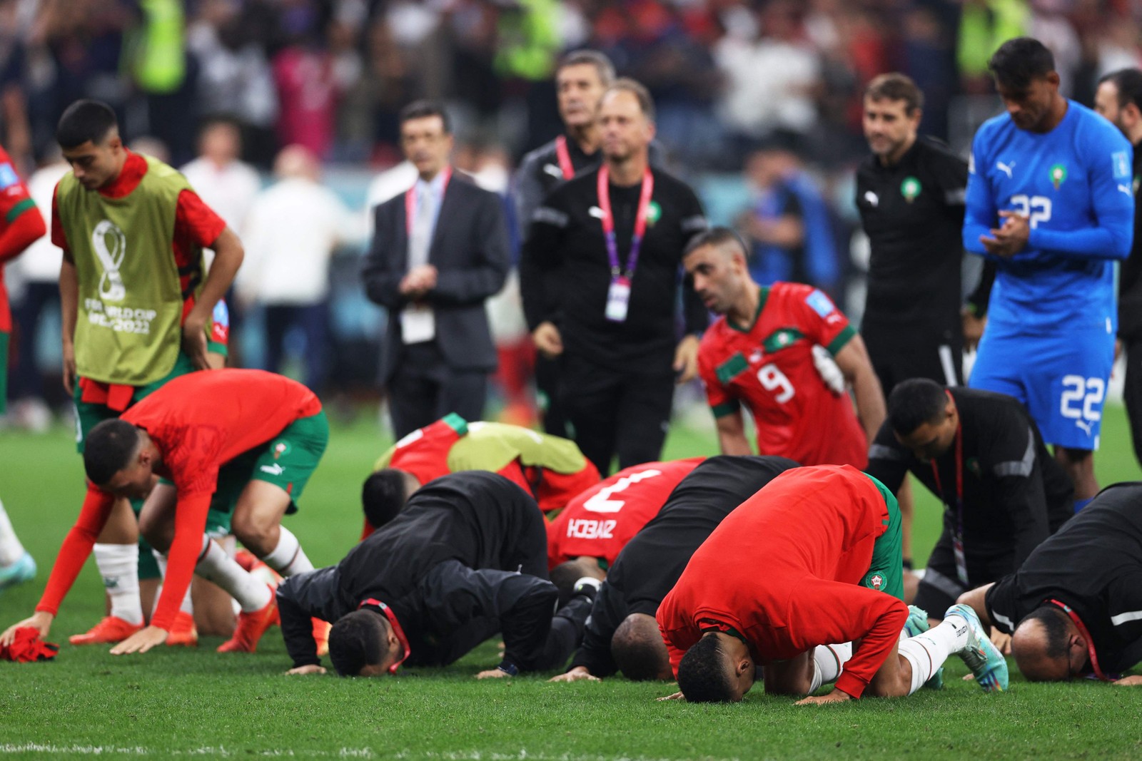 Em gesto de reverência, marroquinos rezam para a torcida após derrota por 2 a 0. Foi a melhor campanha africana na história das Copas — Foto: ADRIAN DENNIS/AFP