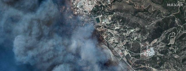 Na imagem, um incêndio perto de Gennadi, na ilha de Rodes. Desde o início do verão, uma onda de calor assolou milhões de pessoas em grande parte do hemisfério norte. Segundo previsões de especialistas, julho pode se tornar o mês mais quente já registrado na história. — Foto: Handout / Satellite image ©2023 Maxar Technologies / AFP