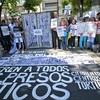 Manifestantes seguram cartazes contra o governo do presidente Nicolás Maduro e exigem liberdade para presos políticos, durante protesto na embaixada brasileira em Caracas - JUAN BARRETO/AFP