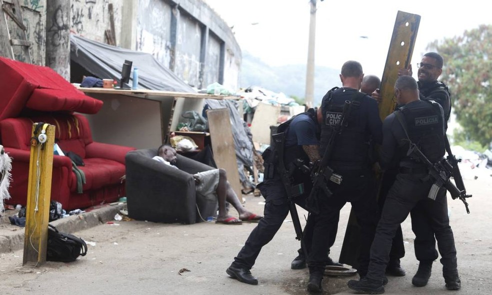 Policiais retiram barricada colocada por bandidos — Foto: Fabiano Rocha / Agência O Globo