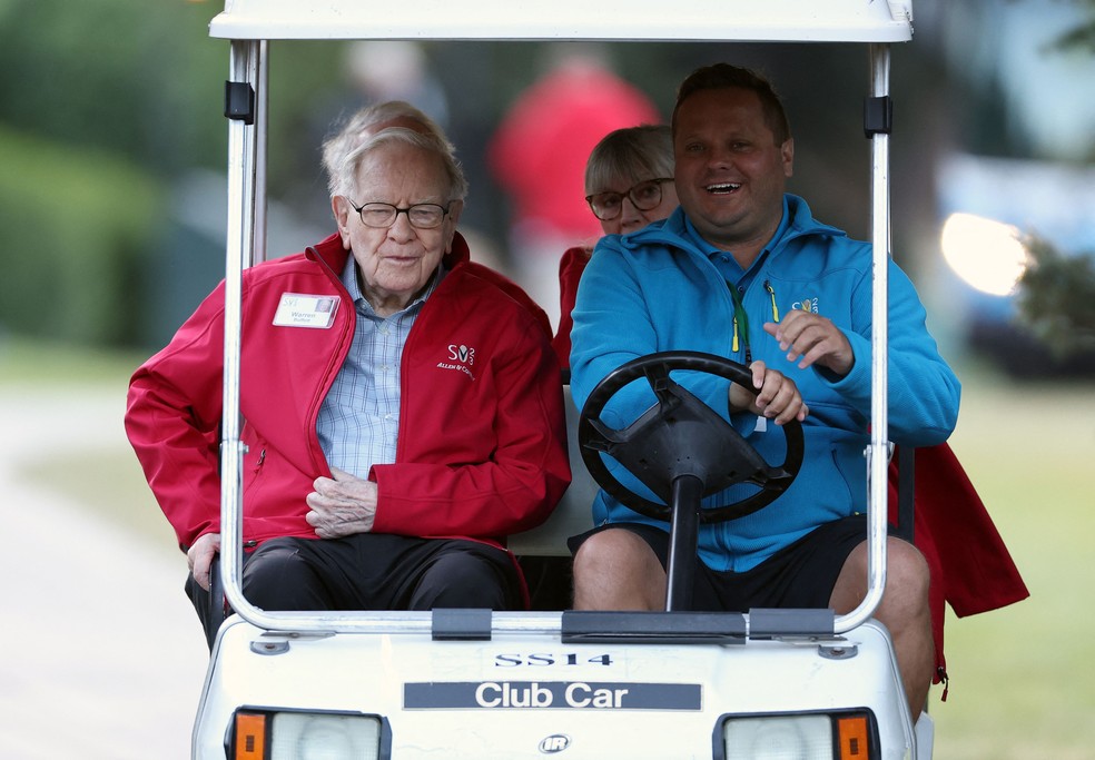 Warren Buffett (esq.), um dos homens mais ricos do mundo, em carrinho de golf  — Foto: AFP