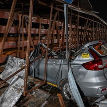 Carro fica fortemente danificado no local onde outdoor desabou em um posto de gasolina após uma tempestade de areia em Mumbai. — Foto: Punit PARANJPE / AFP