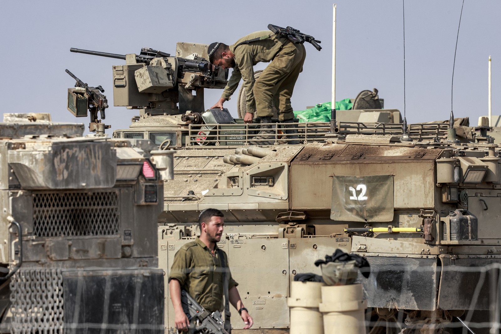 Soldados circulam entre tanques 1500, os mais recentes das forças de Israel — Foto: AFP