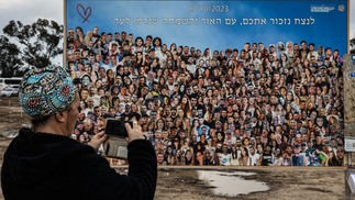 Um mosaico gigante, composto por fotos das vítimas com a mensagem "Lembraremos de vocês pela eternidade", recebe os visitantes no estacionamento de Reim. — Foto: RONALDO SCHEMIDT / AFP