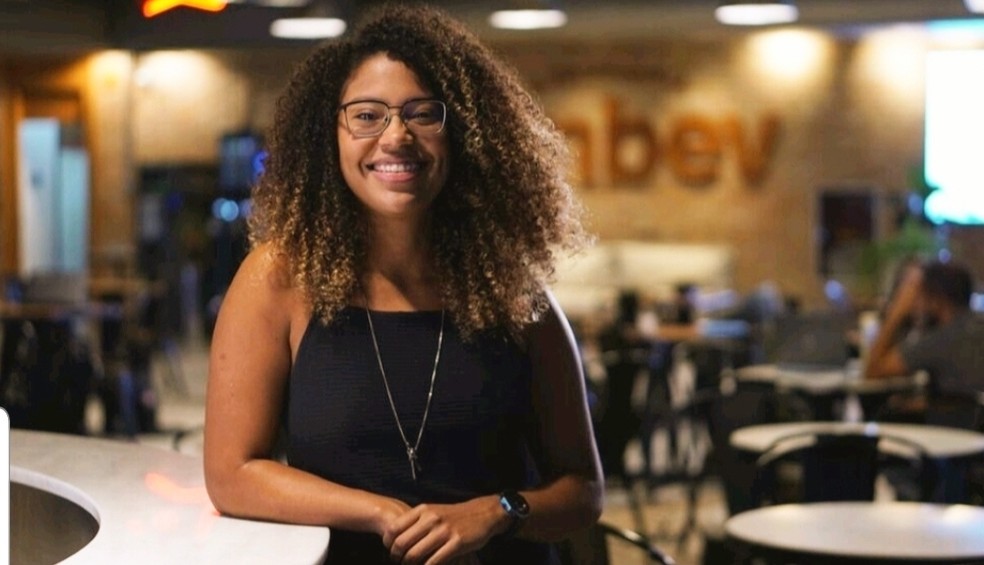 AÇÃO. Integrante da equipe de marketing da Ambev, Indianara Dias de Oliveira está, há dois anos, à frente do grupo de diversidade racial da cervejaria. Foi uma das funcionárias negras que deu sugestões à empresa no processo de estruturação do programa Representa. “Enquanto uma mulher negra dentro do mundo corporativo pude ver e viver na prática o quão distante estamos do mundo ideal. É muito gratificante poder contribuir ativamente. Tem funcionado muito bem a gente levar a nossa vivência, mas também aprender mais sobre o cenário que está posto. Esse diálogo é muito bom para os dois lados”, diz. Divulgação — Foto:         