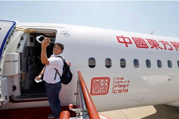 Passageiro tira um self ao embarcar no primeiro jato de passageiros produzido na China, o C919