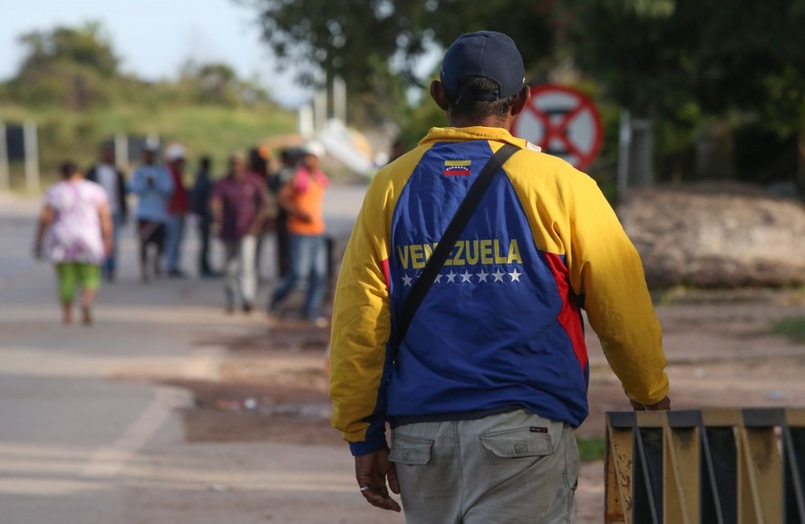 Homem venezuelano caminhando em Pacaraima, cidade brasileira na fronteira com o país responsável pelo primeiro acolhimento dos migrantes