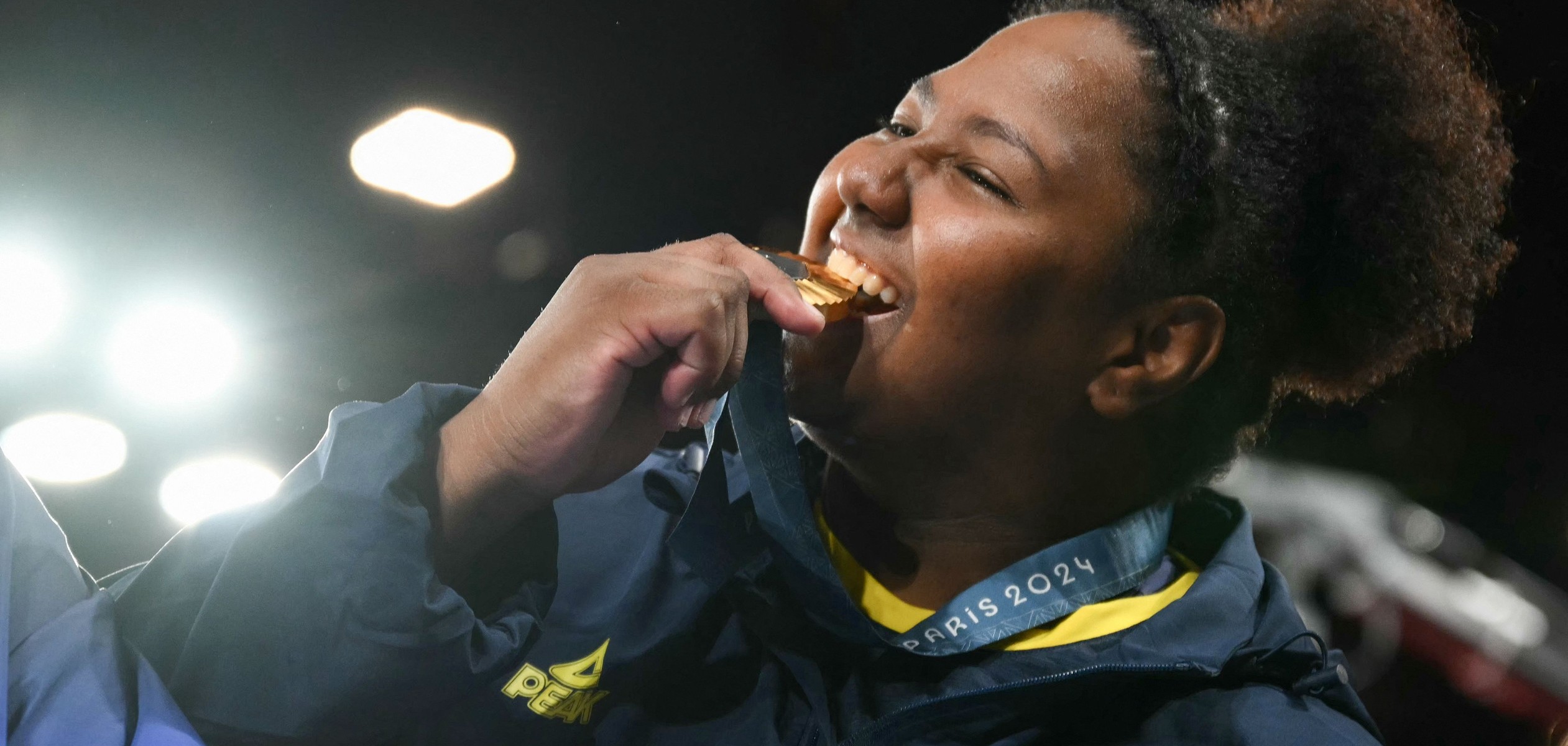 Beatriz Souza mordendo a medalha de ouro em gesto tradicional dos medalhistas olímpicos