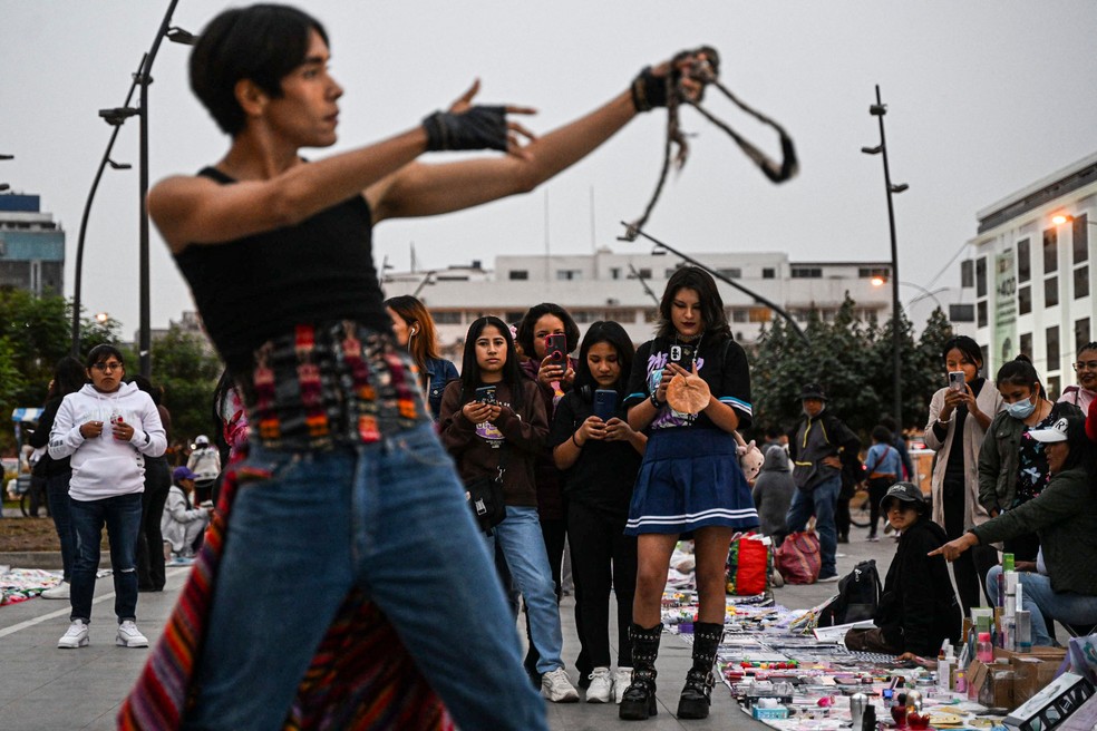 O artista peruano Lenin Tamayo em ação nas ruas de Lima. Ele criou uma versão quechua do K-pop, o Q-pop — Foto: AFP