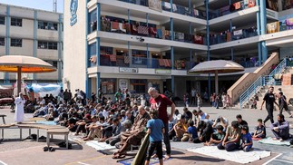 Palestinos se reúnem para as orações semanais muçulmanas das sextas-feiras no playground de uma escola administrada pela Agência das Nações Unidas de Assistência e Obras para Refugiados Palestinos (UNRWA) em Rafah, no sul da Faixa de Gaza — Foto: Mohammed ABED/AFP