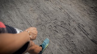 Erik Cardoso costuma escrever no chão de carvão da pista do Sesi, onde treina: agradecimentos a Deus e também tempos aleatórios; na foto ele marca o seu recorde brasileiro: 9s97 — Foto: Anna Carolina Negri