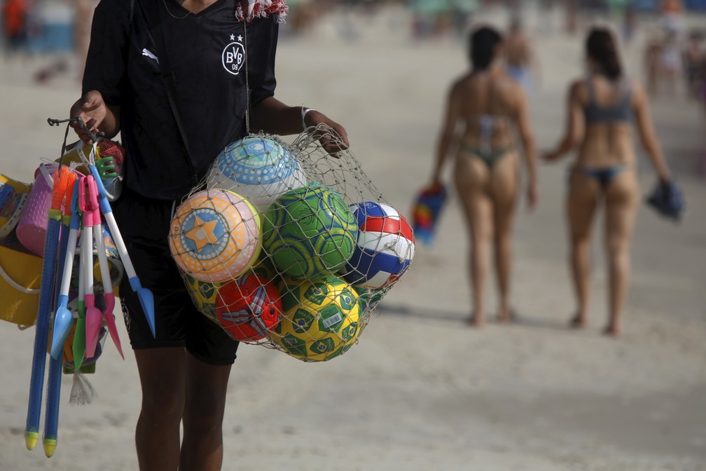 Ambulantes trabalham logo cedo na praia de Copacabana — Foto: Custódio Coimbra/Agência O Globo