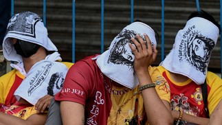 Devotos católicos descansam fora da Igreja de Quiapo durante a celebração da Festa do Nazareno Negro, em Manila. — Foto: JAM STA ROSA / AFP