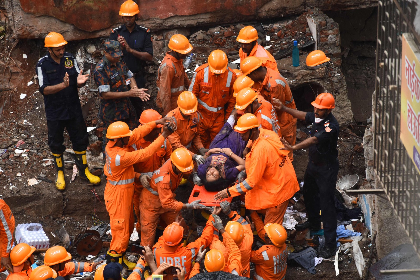 Equipes de resgate retiram sobrevivente dos escombros de um prédio que desmoronou, em Mumbai, na Índia  — Foto: IMTIYAZ SHAIKH / AFP