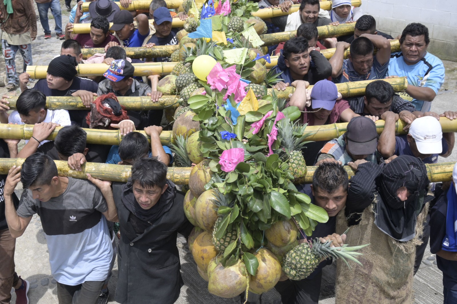 Homens carregam frutas em agradecimento pela colheita do ano durante as festividades de Santa Cruz em Santa Maria Ostuma, 65 km a leste de San Salvado  — Foto: MARVIN RECINOS / AFP