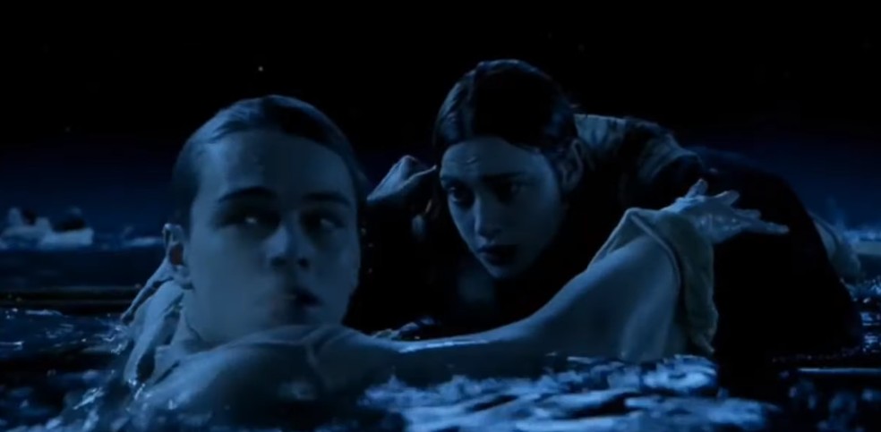 Parte da clássica cena de Jack (Leonardo DiCaprio) ajudando Rose (Kate Winslet) a subir no item que salvará sua vida — Foto: Reprodução