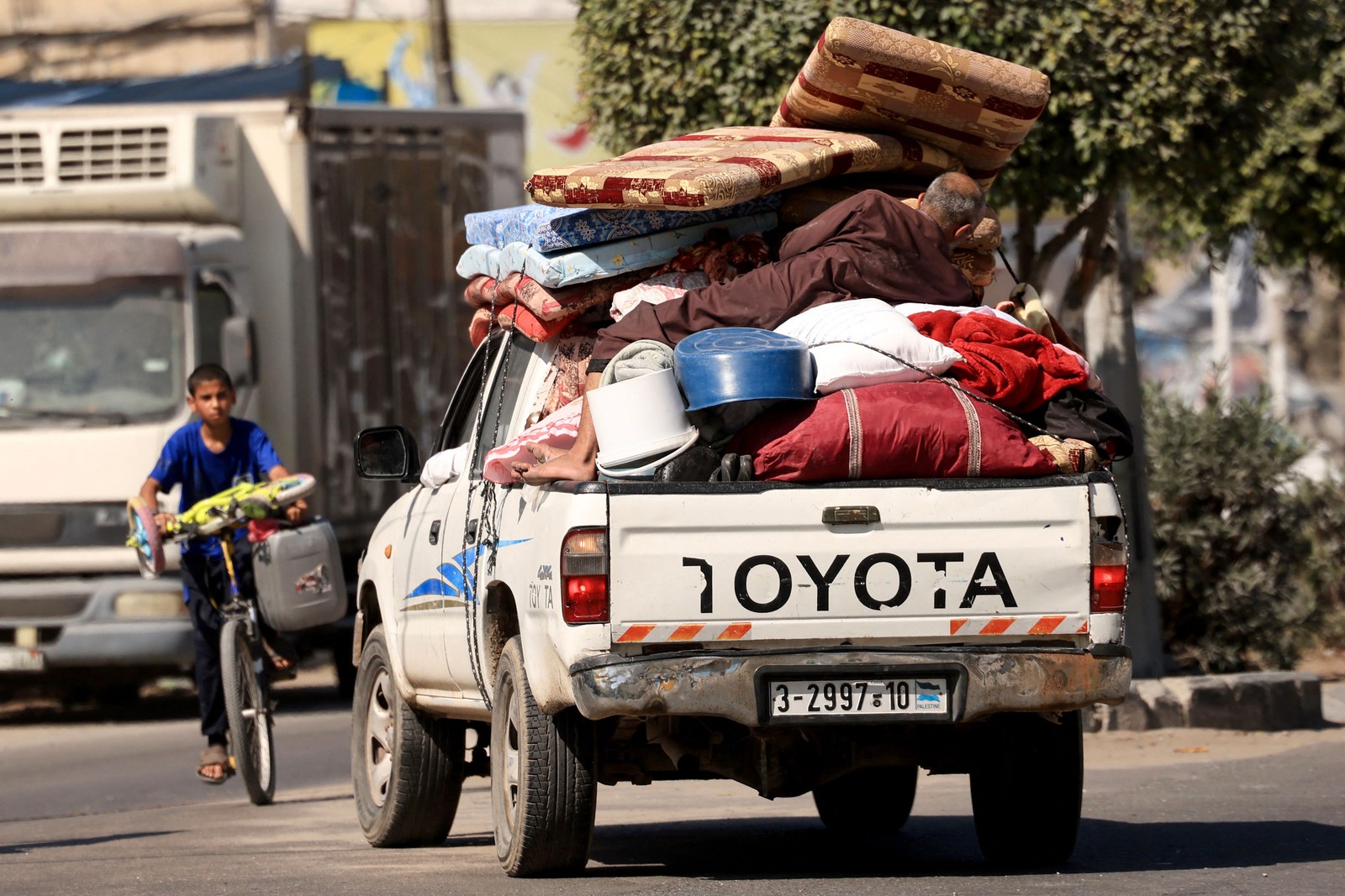 Palestinos com seus pertences fogem para áreas mais seguras na Cidade de Gaza após ataques aéreos israelenses — Foto: Mahmud Hams / AFP