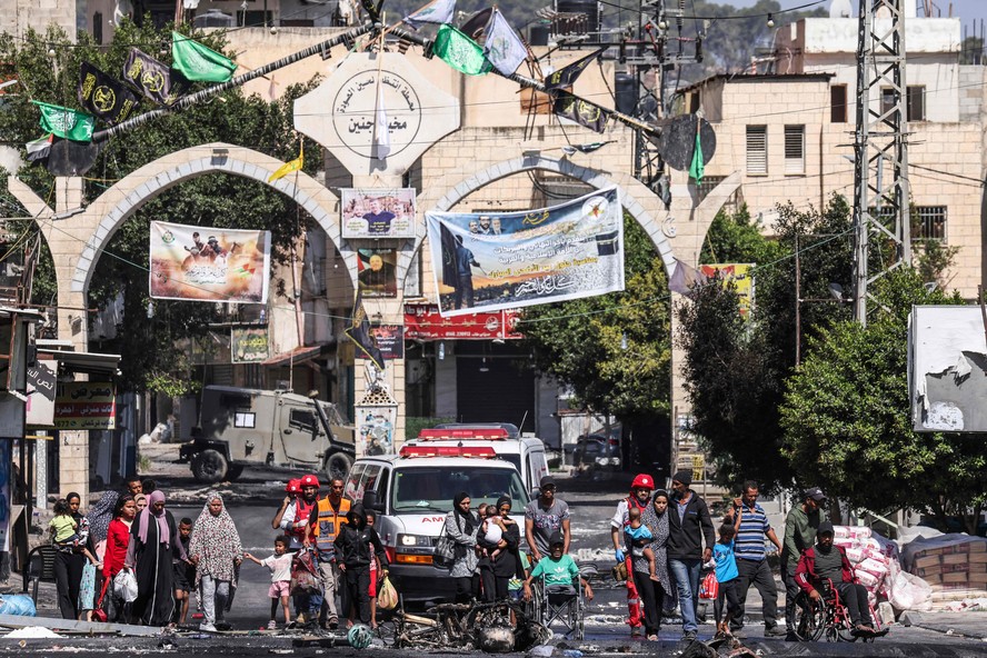 Pessoas fogem do campo de refugiados de Jenin, na Cisjordânia ocupada, durante uma operação militar israelense em andamento