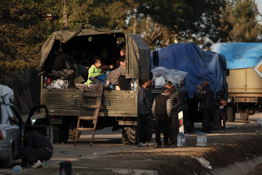 Refugiados de Nagorno-Karabakh ficam perto de seus veículos após cruzarem a fronteira perto de Kornidzor na Armênia