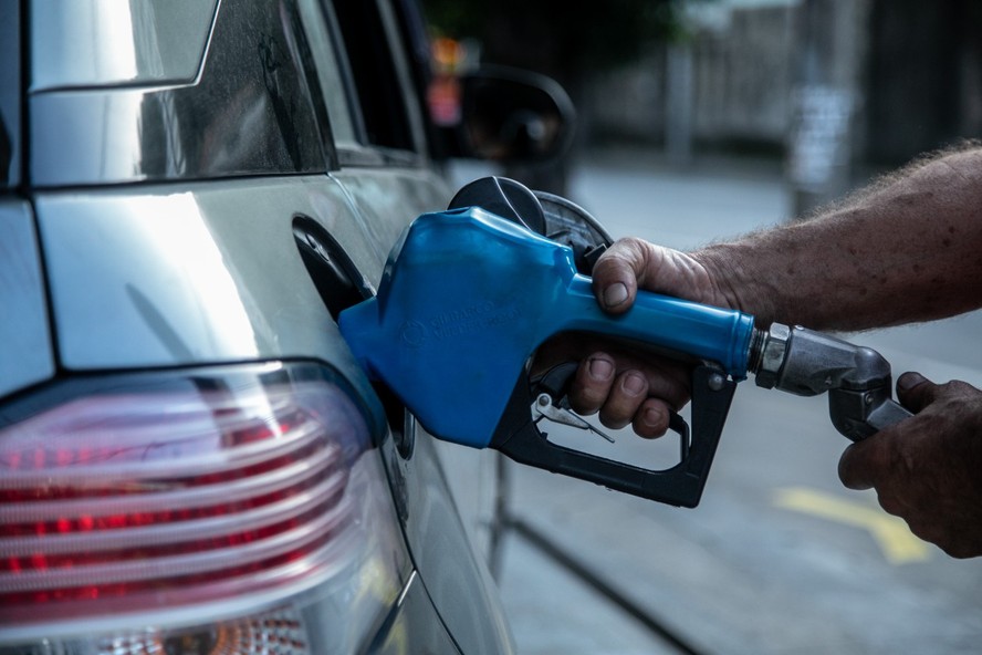 Frentista abastece carro em posto de gasolina no Rio: alta do dólar influencia nos preços