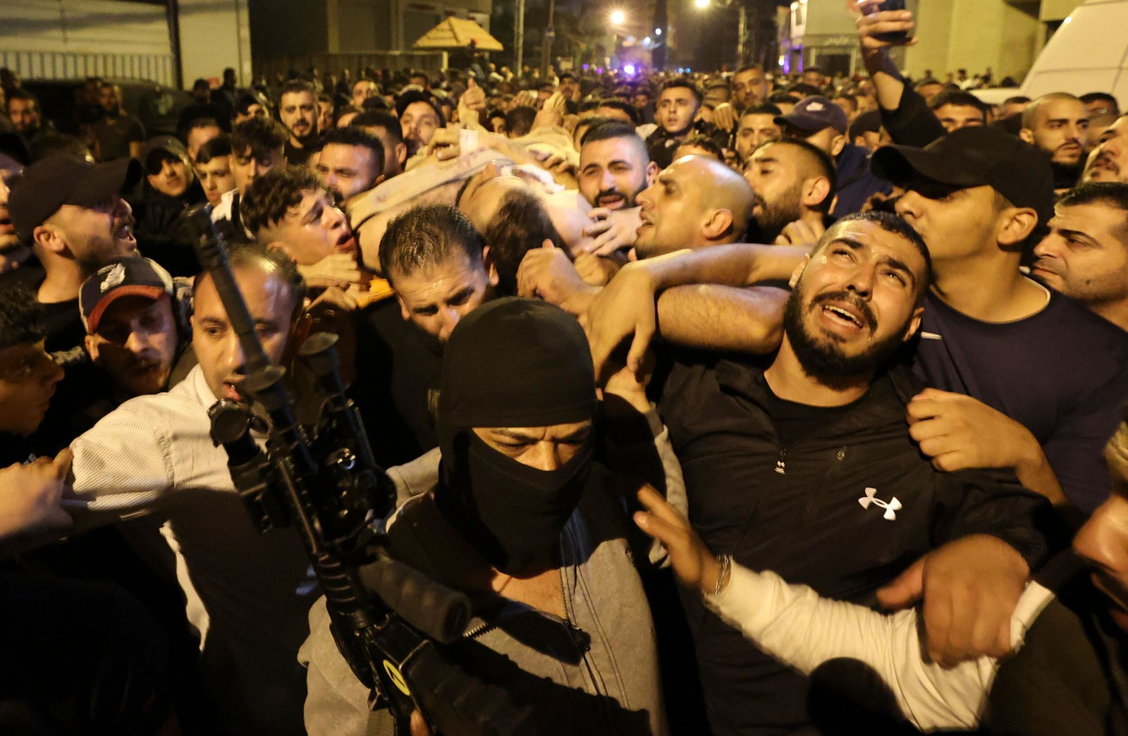 Homens carregam o corpo do suposto líder da Lion's Den de um hospital em Nablus depois que ele foi morto em um confronto com soldados israelenses, na Cisjordânia. No total, quatro palestinos foram mortos mortos e quase 20 outros feridos — Foto: JAAFAR ASHTIYEH/AFP