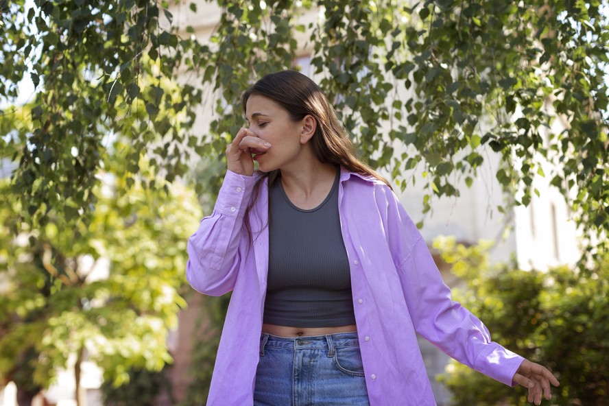 Mulher espirrando em contato com o sol