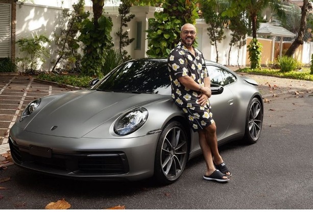 O cantor Belo posa com um de seus carros de luxo