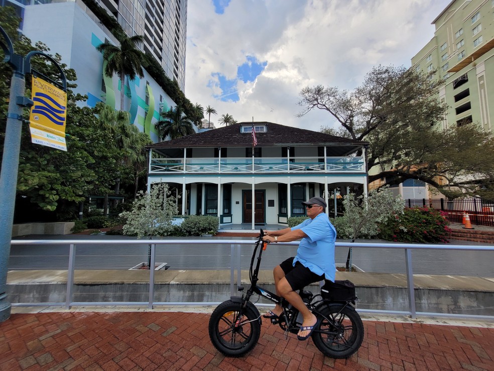 Ciclista passa em frente ao Historic Stranahan House Museum, construção mais antiga da região de Fort Lauderdale, na Flórida — Foto: Eduardo Maia