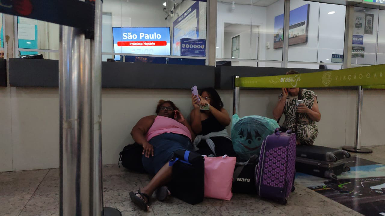 Passageiros se protegem atrás de balcão na Rodoviária Novo Rio