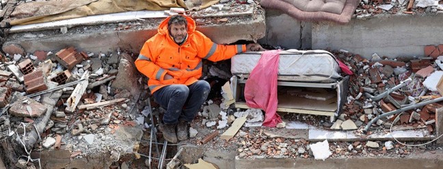 Mesut Hancer segura a mão de Irmak, de 15 anos, morta no terremoto na Turquia — Foto: Adem ALTAN / AFP