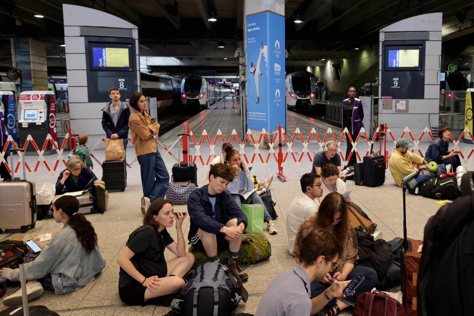 Com sistema de trens rápidos afetados na França, passageiros sentam no chão da estação Montparnasse à espera de uma solução; problemas devem durar até o fim de semana — Foto: Thibaud Moritz / AFP