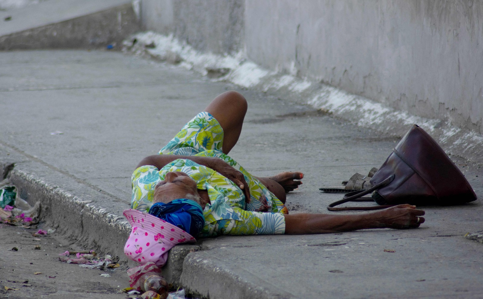 Uma mulher idosa, que foi baleada no pé, grita por socorro em Porto Príncipe, Haiti. — Foto: Clarens SIFFROY / AFP